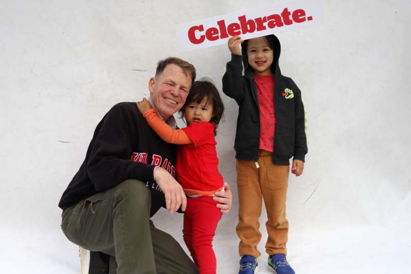 a man holding a child and a sign