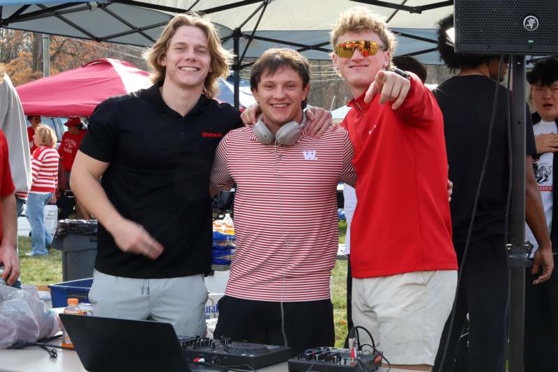 a group of men standing next to a table with electronic equipment
