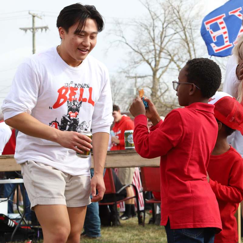 a man in a white shirt and shorts standing next to a boy