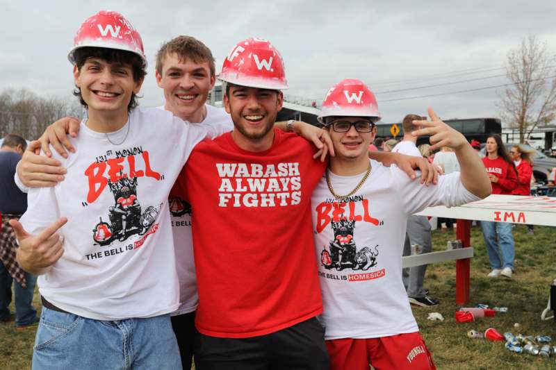 a group of young men wearing red and white t-shirts and matching hats