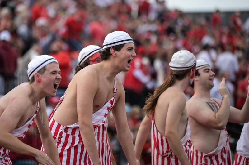 a group of men wearing red and white striped overalls