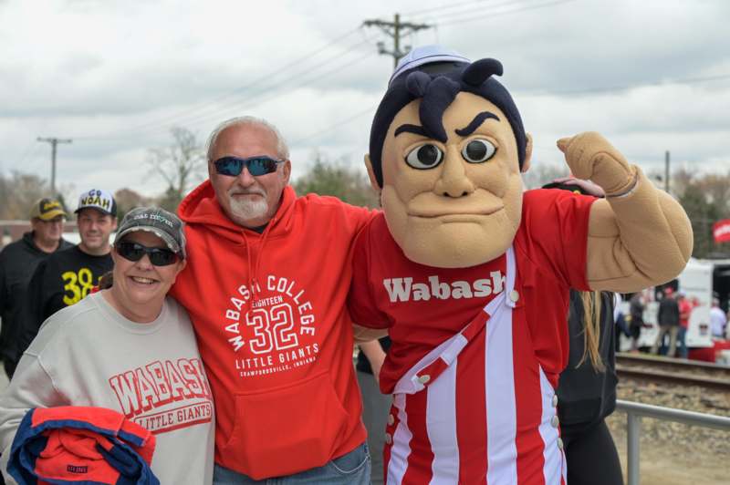 a man and woman posing with a mascot