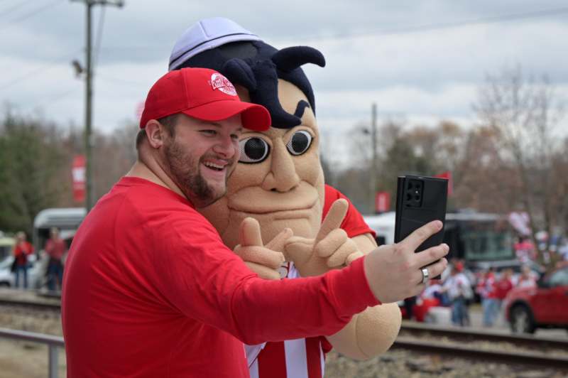 a man taking a selfie with a mascot