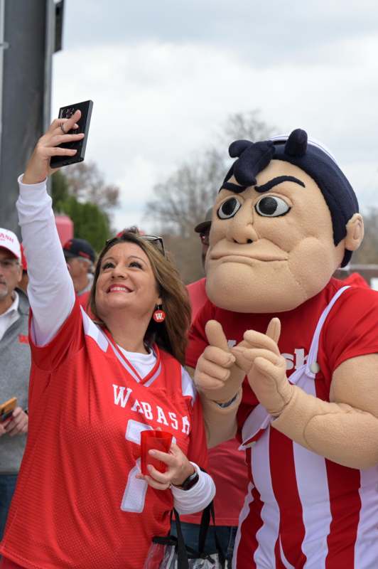 a woman taking a selfie with a mascot