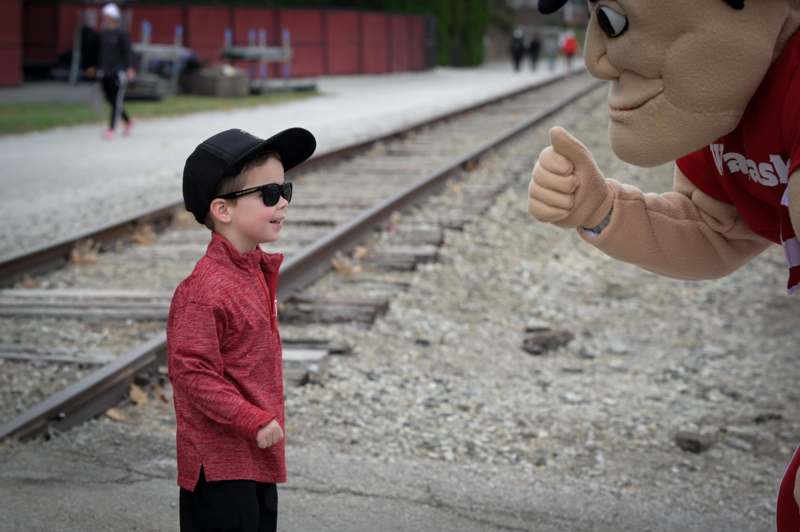 a boy standing next to a person wearing a garment