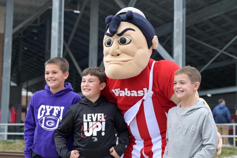 a group of boys posing for a picture with a mascot