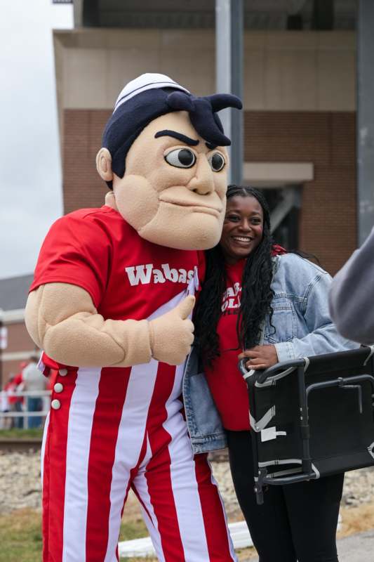a woman standing next to a person in a mascot garment