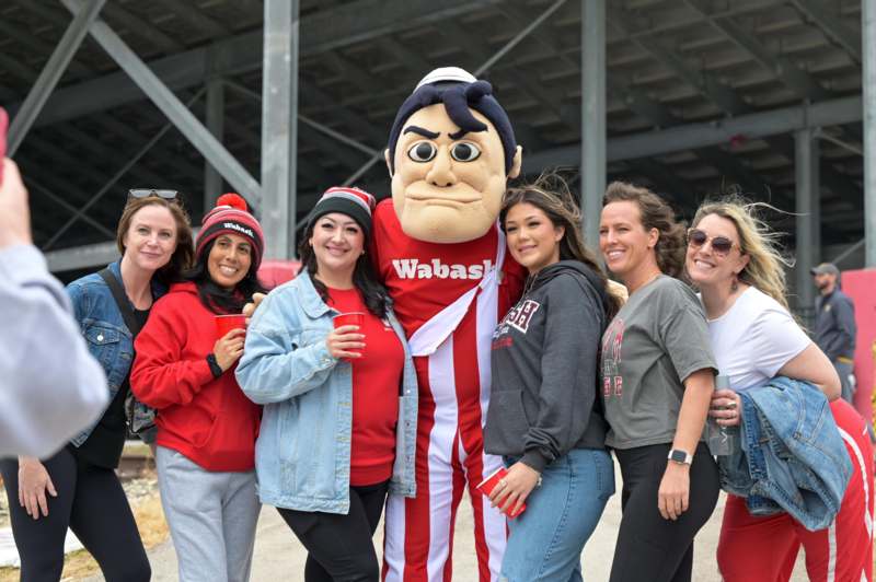 a group of women posing for a picture with a mascot