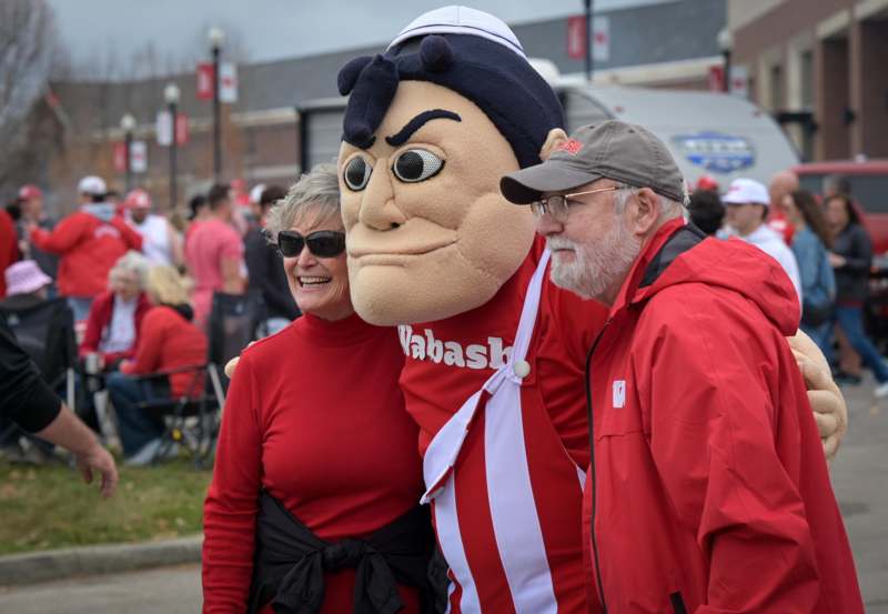 a man and woman posing with a mascot