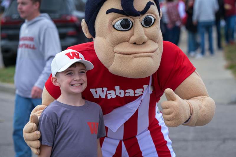 a boy posing with a mascot