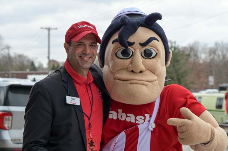 a man standing next to a mascot