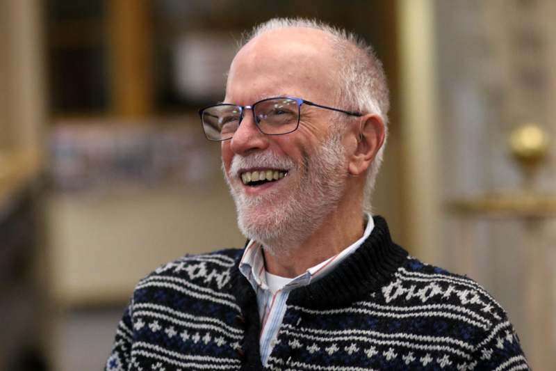 a man wearing glasses and a sweater