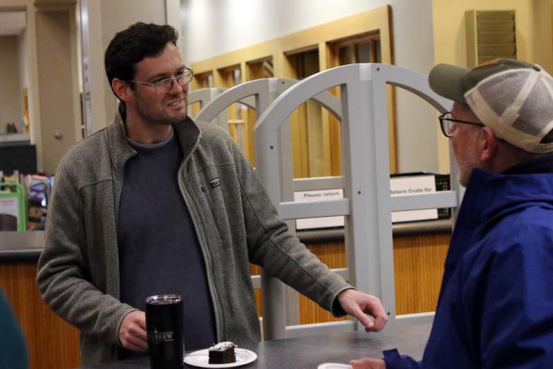 a man standing next to another man