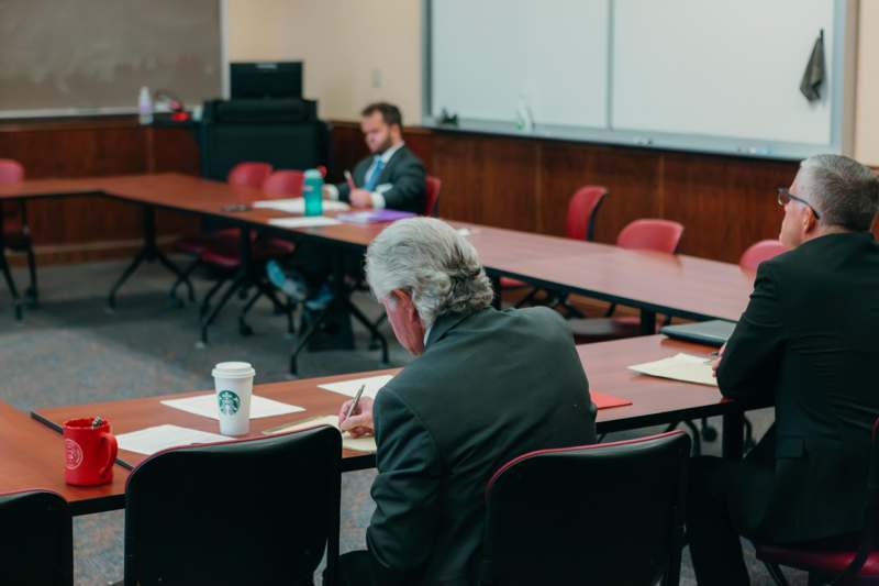 a man sitting at a table with a paper on it