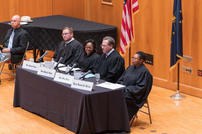 a group of people sitting at a table with microphones