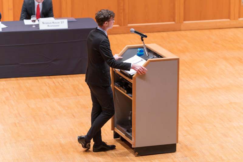 a man standing at a podium with a microphone
