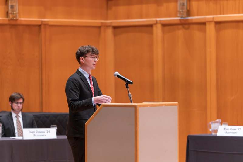 a man standing at a podium with a microphone