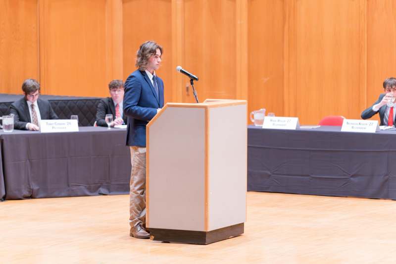 a man standing at a podium with a microphone
