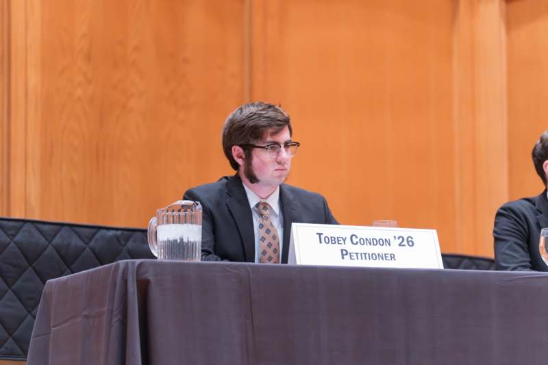 a man sitting at a table with a sign