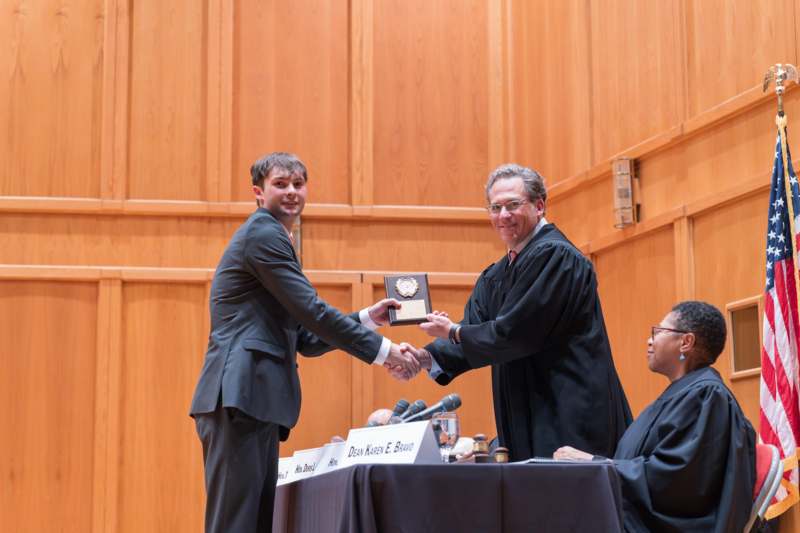 a man shaking hands with a man in a robe