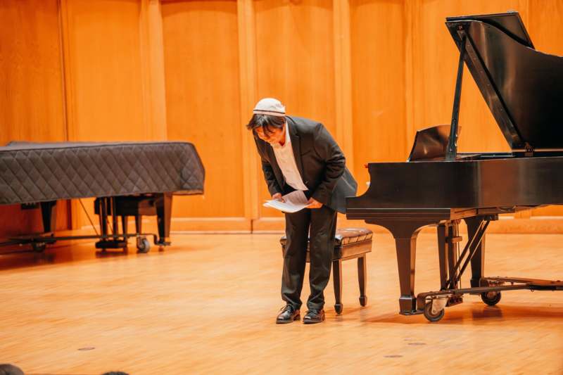 a man standing next to a piano