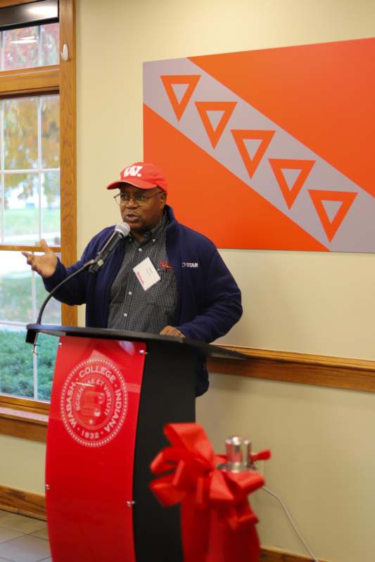 a man standing at a podium speaking into a microphone
