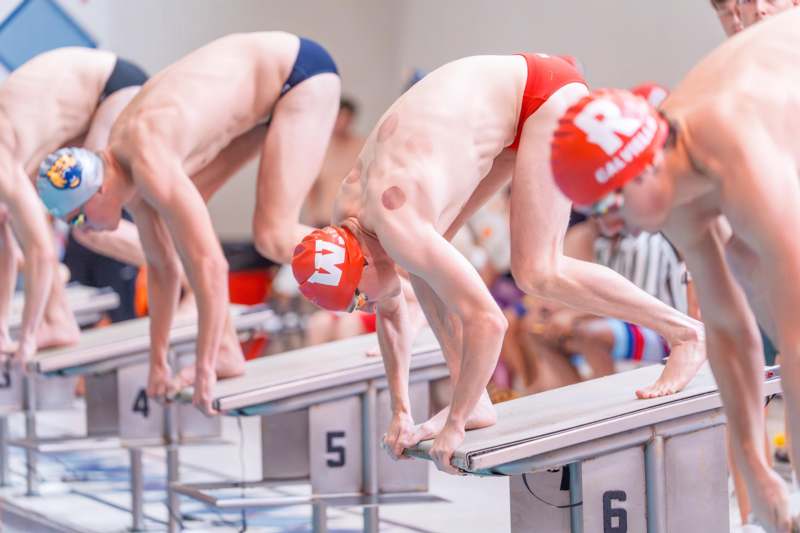 a group of swimmers ready to start a swim meet