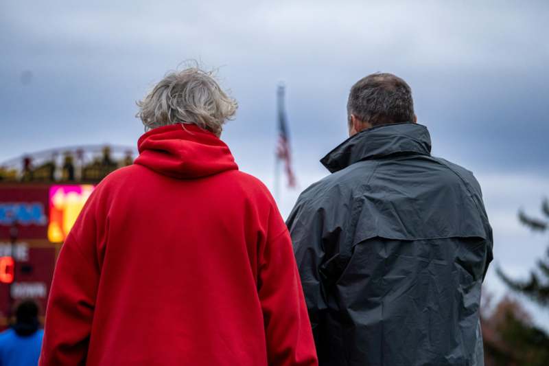 a man and woman standing in front of a flag