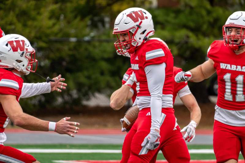 a football player in a red uniform with a football in his hand