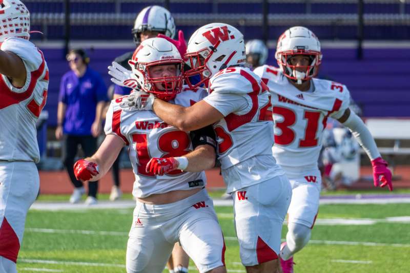 a group of football players hugging on a field
