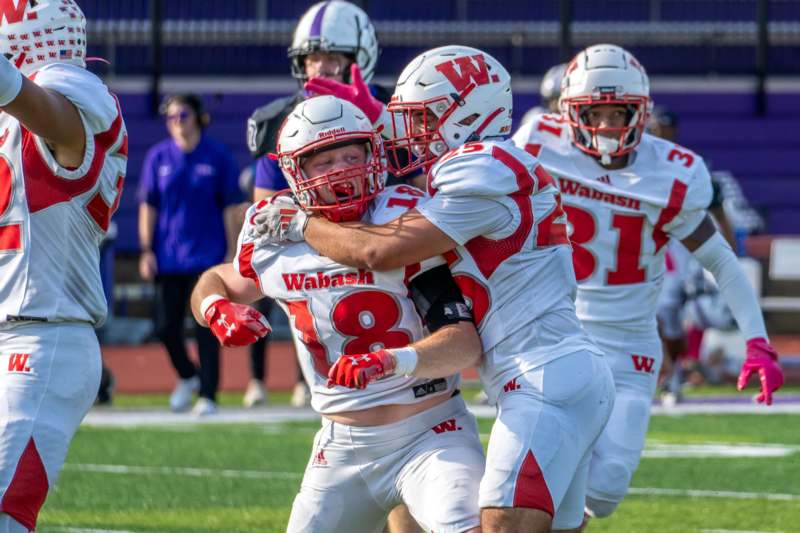 a group of football players hugging on a field