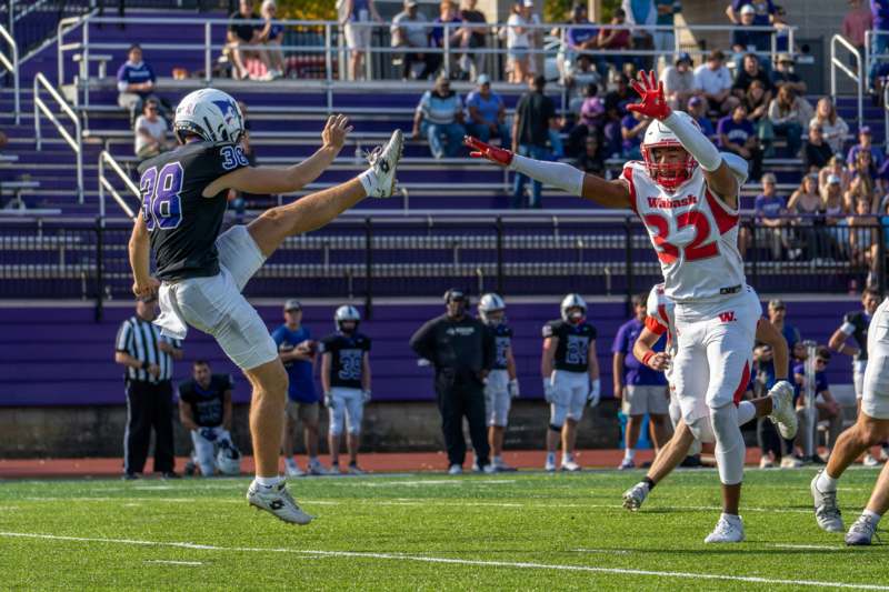 a football player kicking another football player