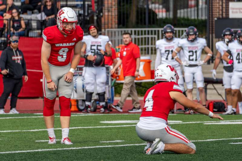 a football player kneeling on the ground with other players in the background