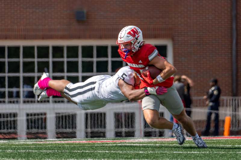 a football player in a red uniform holding a football