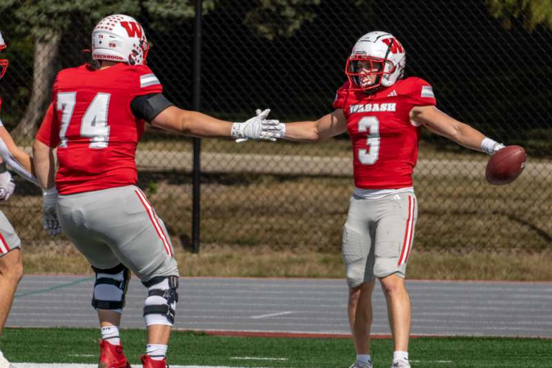 two football players shaking hands on a field