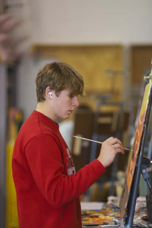 a man painting on a canvas