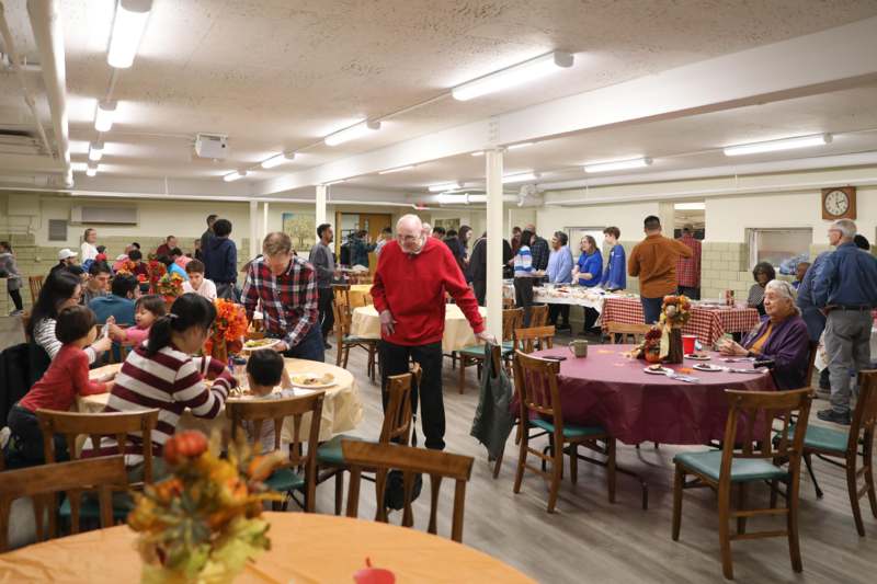 a group of people in a room with tables and chairs