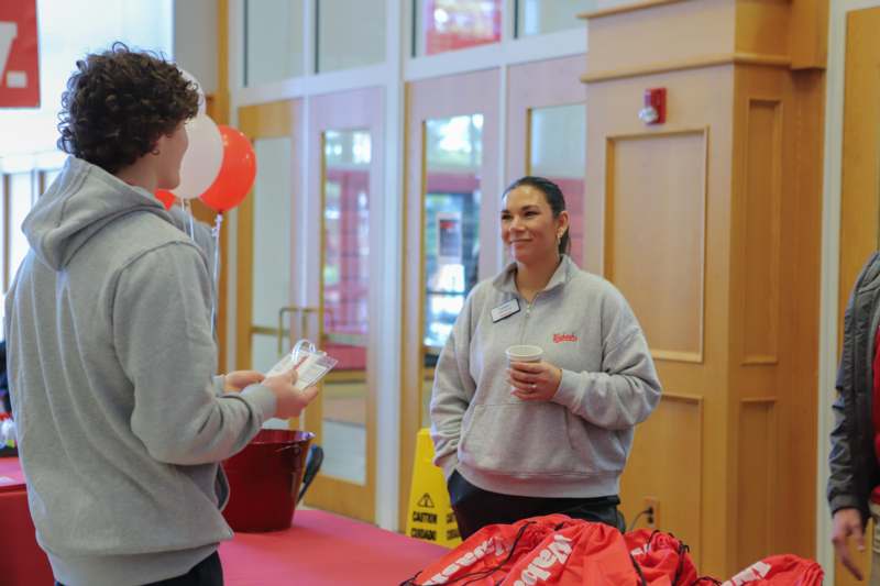 a woman holding a cup and a man holding a plastic cup