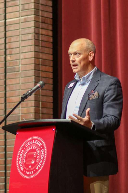 a man standing at a podium with a microphone