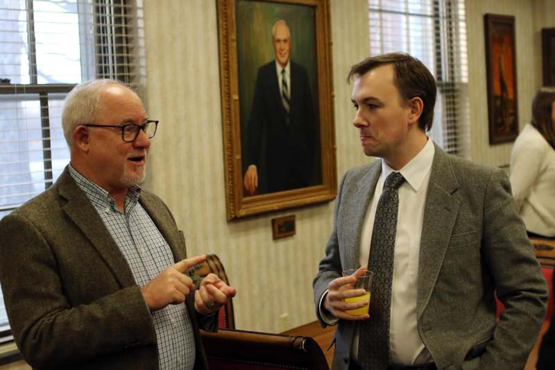 two men in suits talking in a room