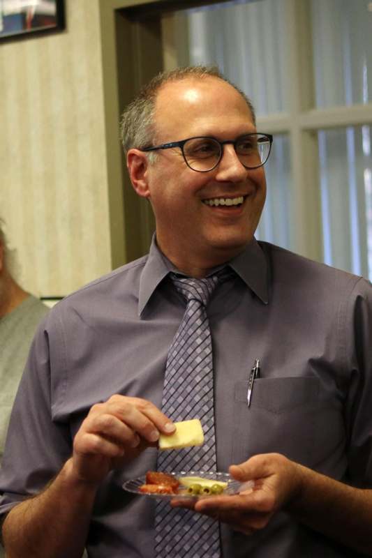 a man wearing glasses and a purple shirt