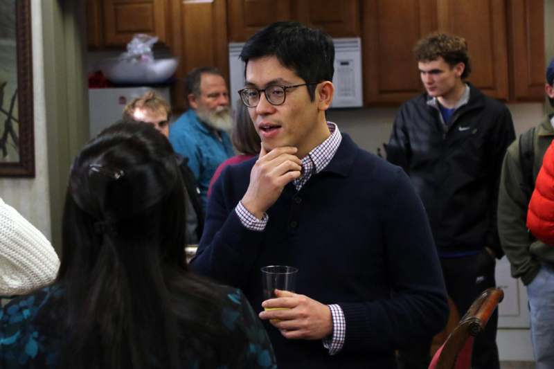 a man holding a cup and looking at another man