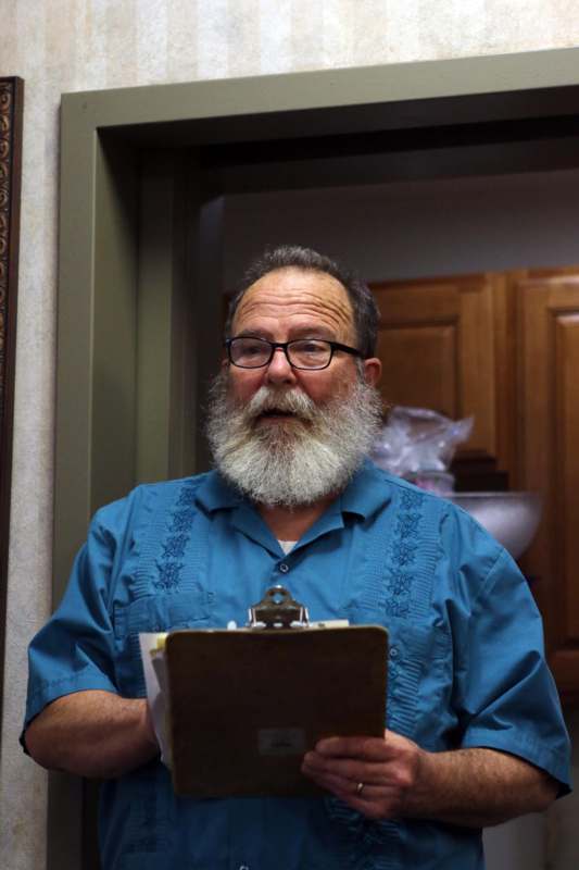 a man with a beard holding a clipboard