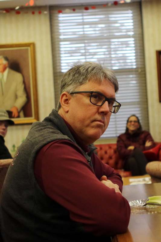 a man sitting at a table with his arms crossed