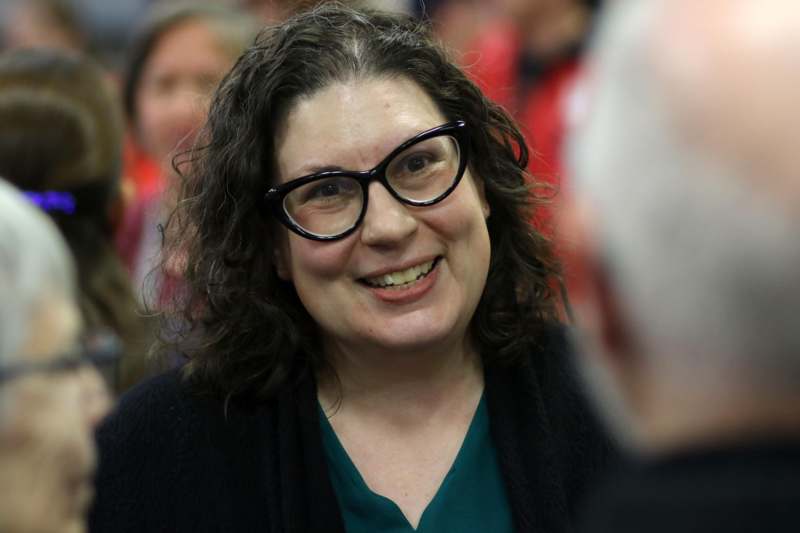 a woman wearing glasses and smiling