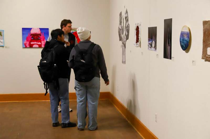 a group of people looking at art on a wall