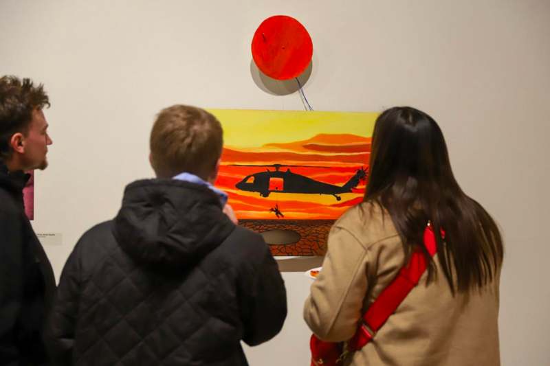 a group of people looking at a painting