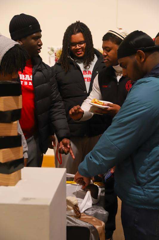 a group of people standing around a table
