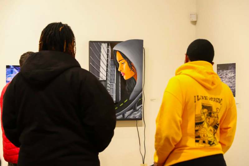 a group of people looking at a painting