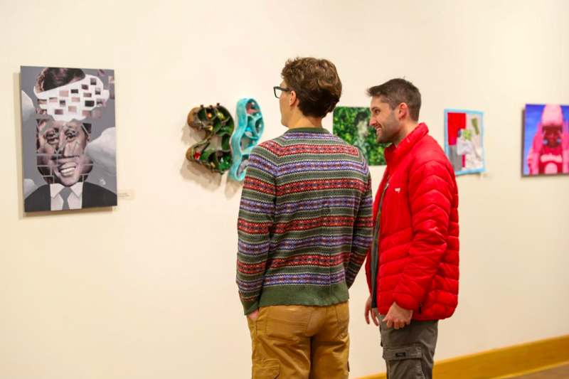two men looking at art on a wall